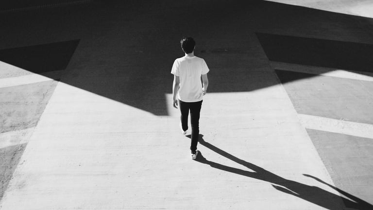 Man jogging in light shirt on geometric concrete surface with angular shadows, black and white photo
