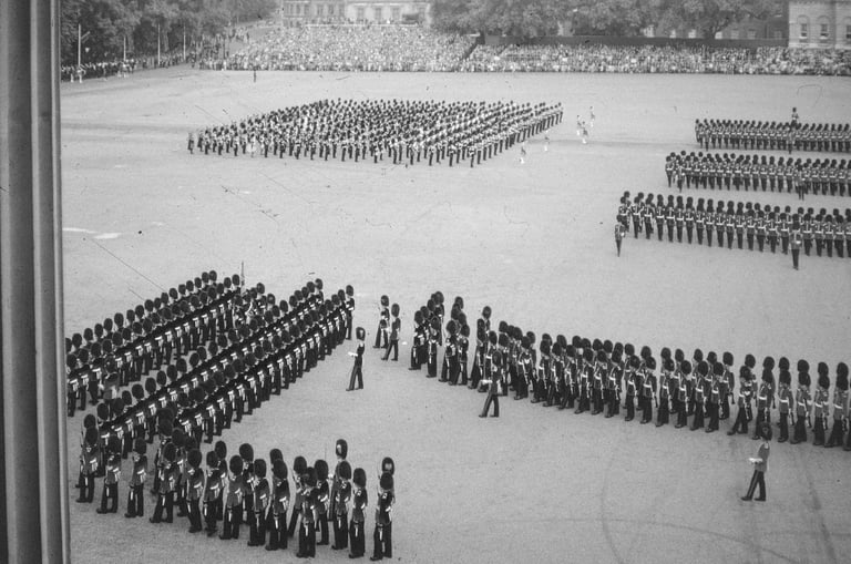 Aerial black and white photograph of military personnel arranged in rectangular formations on a large parade ground or field